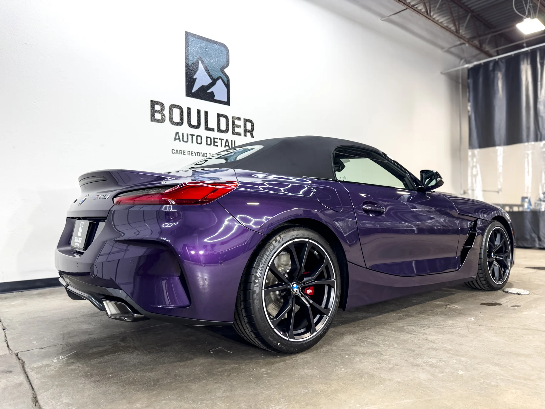 Purple BMW Z4 photographed beneath Boulder Auto Detail shop lighting