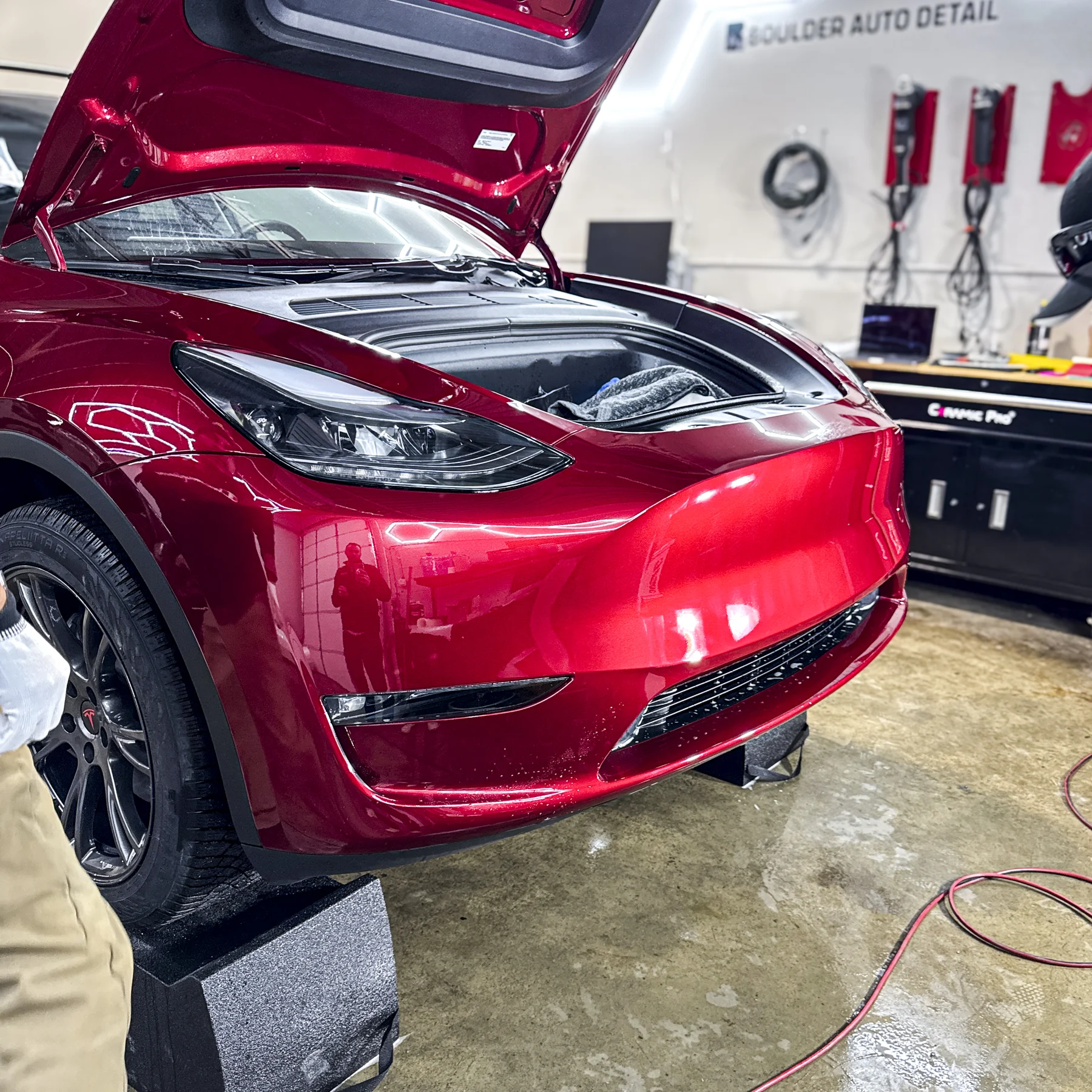Red Tesla rear panel photographed inside Boulder Auto Detail