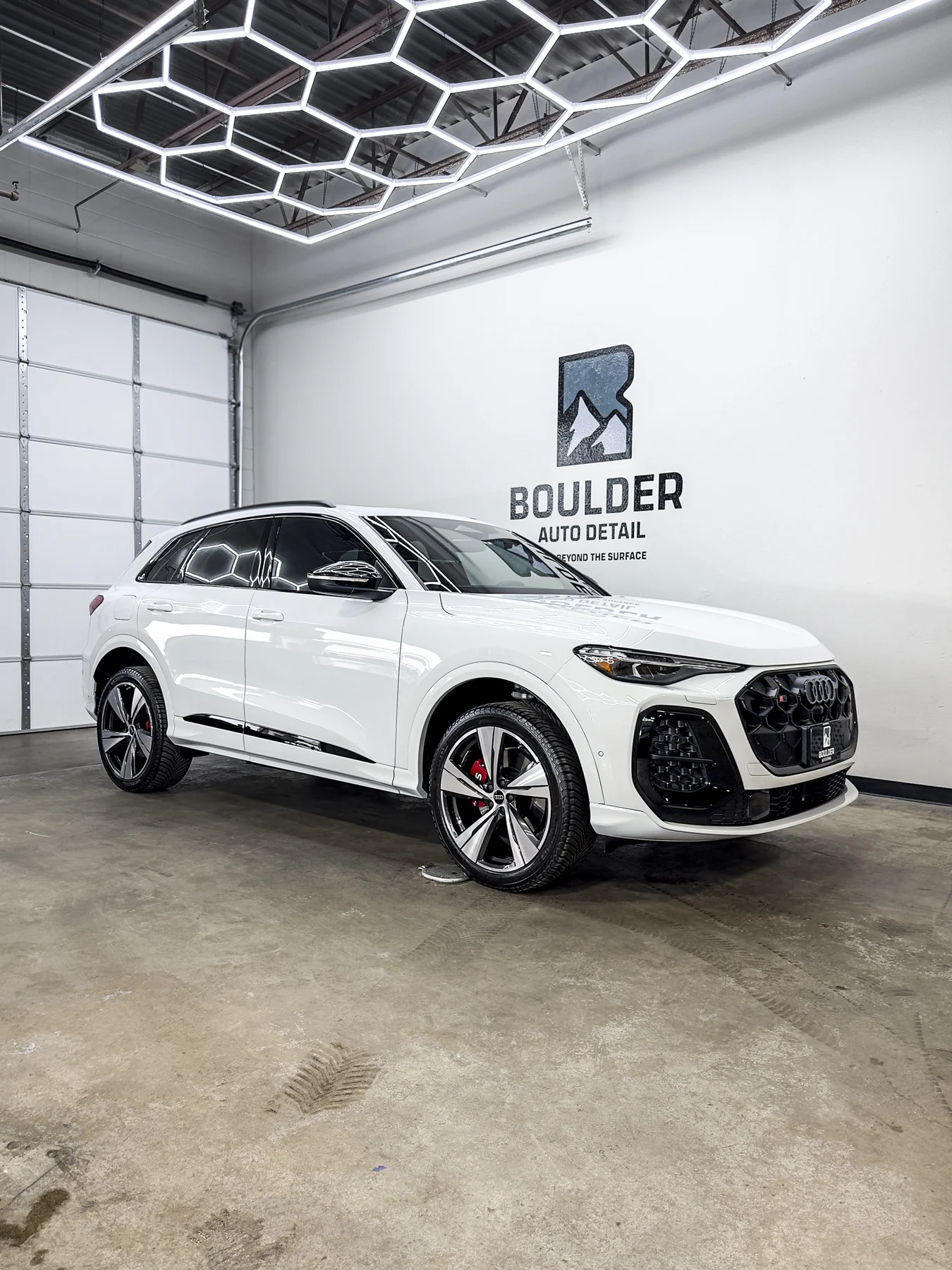 White Audi SUV photographed inside Boulder Auto Detail