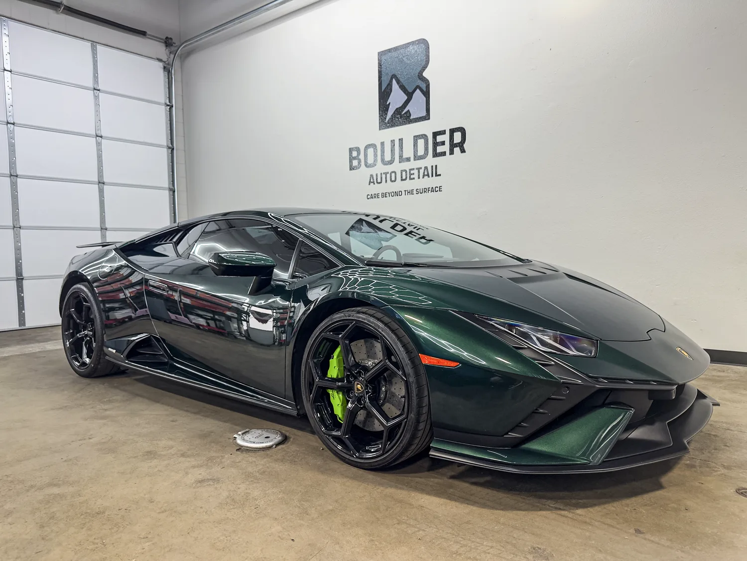 Green Lamborghini showing reflected Boulder shop lighting across the painted finish