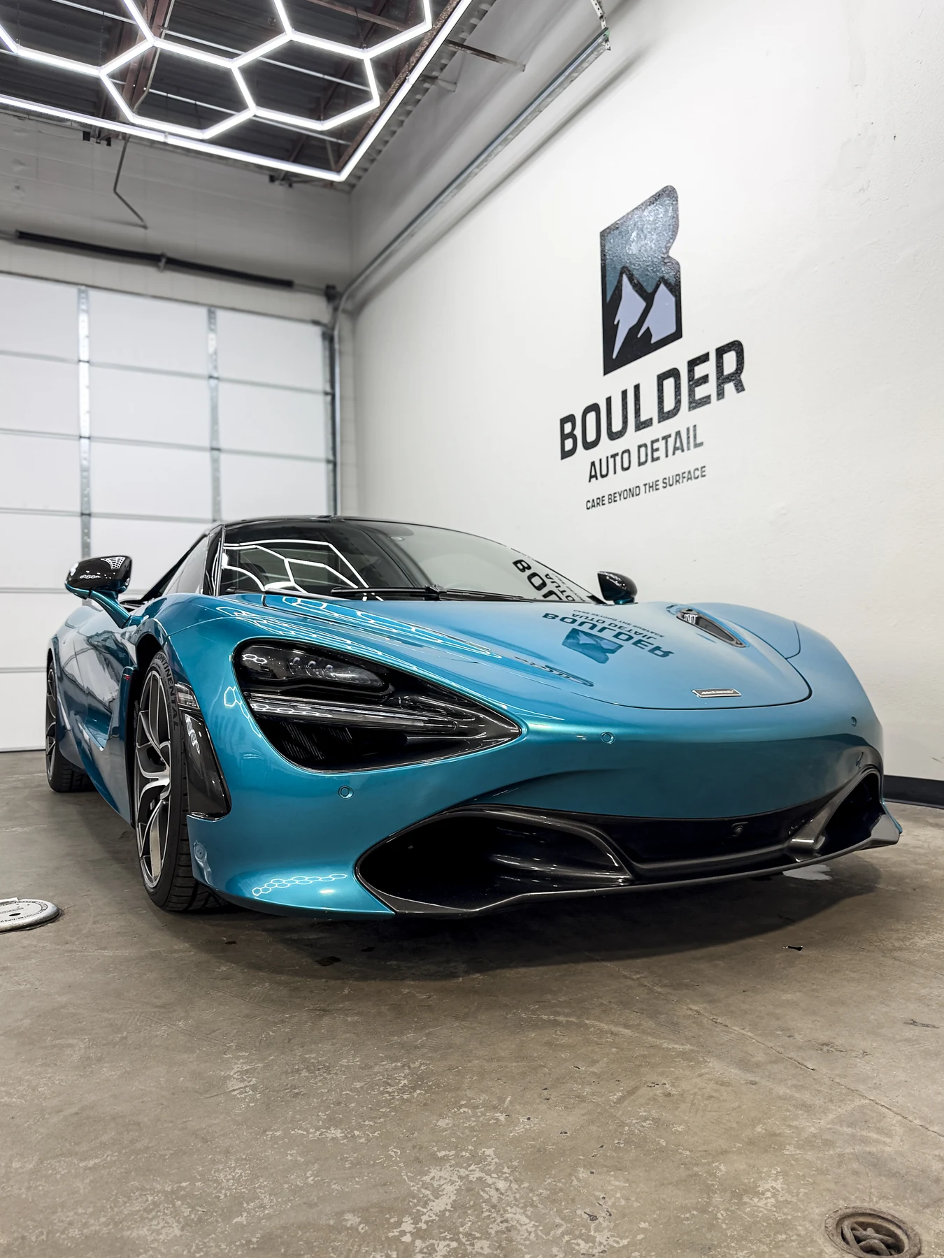 Blue McLaren photographed beneath the Boulder Auto Detail wall mark