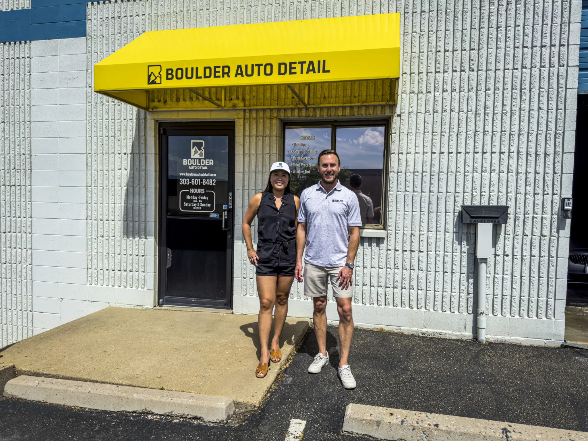 Boulder Auto Detail owners standing outside the Boulder shop entrance