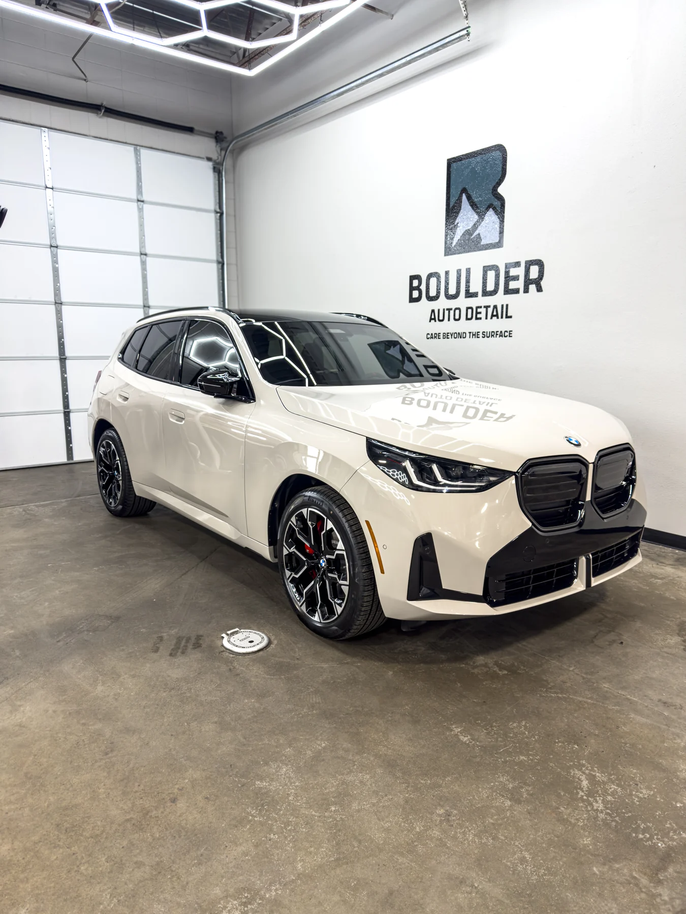 White BMW SUV photographed inside Boulder Auto Detail