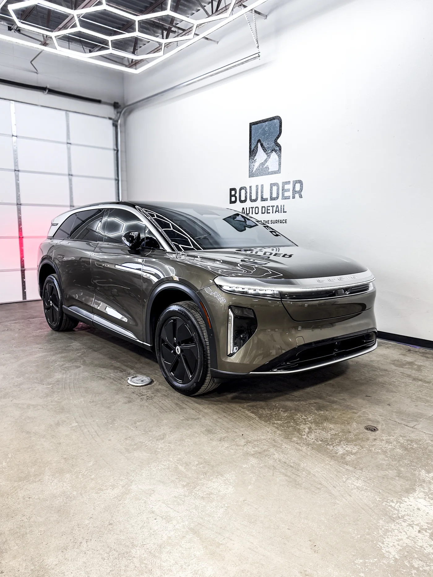 Ceramic-coated Lucid showing a glossy finish under Boulder Auto Detail shop lights